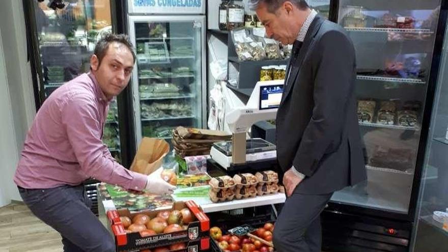 José Ángel Casas Blanco (izquierda) vende tomates alistanos en su frutería de Madrid.