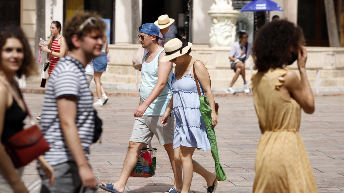 Varias personas intentan protegerse del calor.