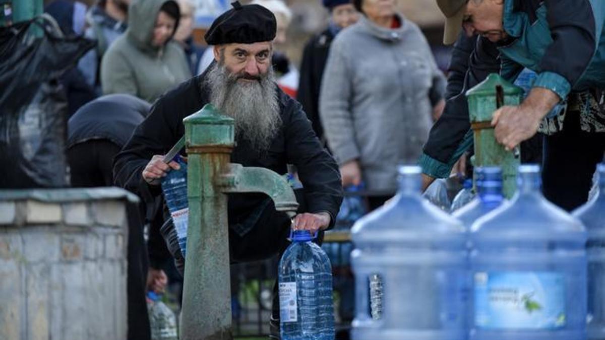 Kyiv (Ucrania), 31/10/2022.- La gente hace cola de una fuente, después de que parte de la capital ucraniana haya quedado sin luz ni suministro de agua por los bombardeos rusos.