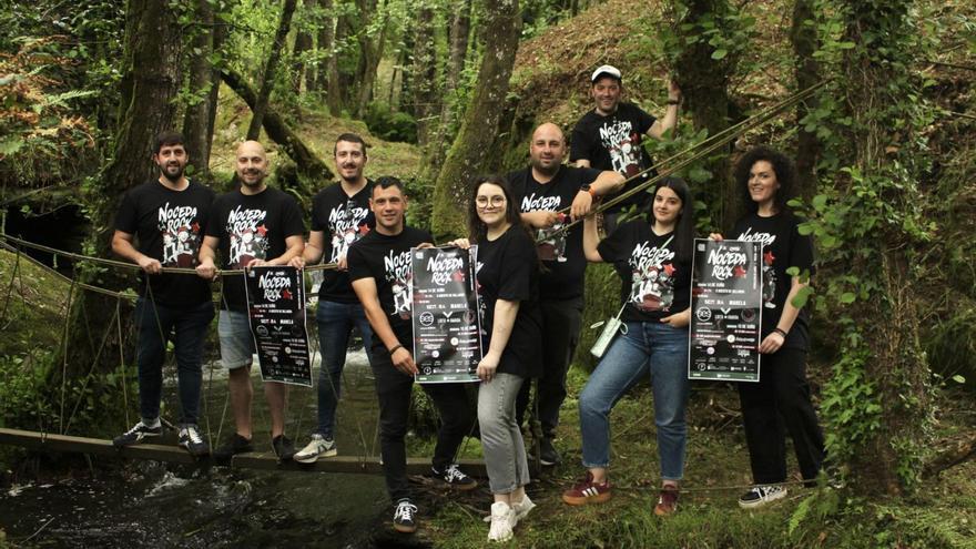 Integrantes da Asociación Cultural Bolarqueira mostran o cartel na paraxe natural do festival.