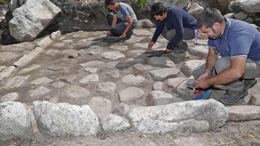 Arqueólogos limpian uno de los estanques de A Robaleira, en Mougás. // J. Lores