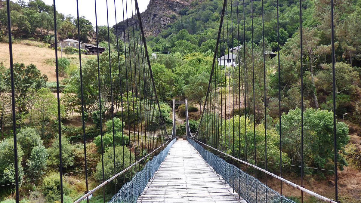 El puente colgante que da entrada peatonal al pueblo de Riodeporcos. | Demelsa Álvarez