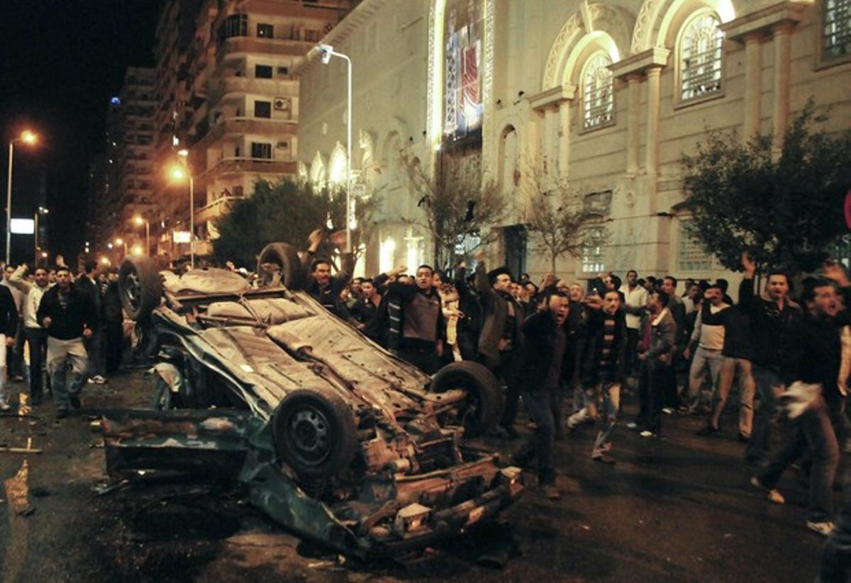 Fieles cristianos protestan ante la iglesia de los Santos inmediatamente después del atentado con coche bomba, este sábado, en la ciudad egipcia de Alejandría.