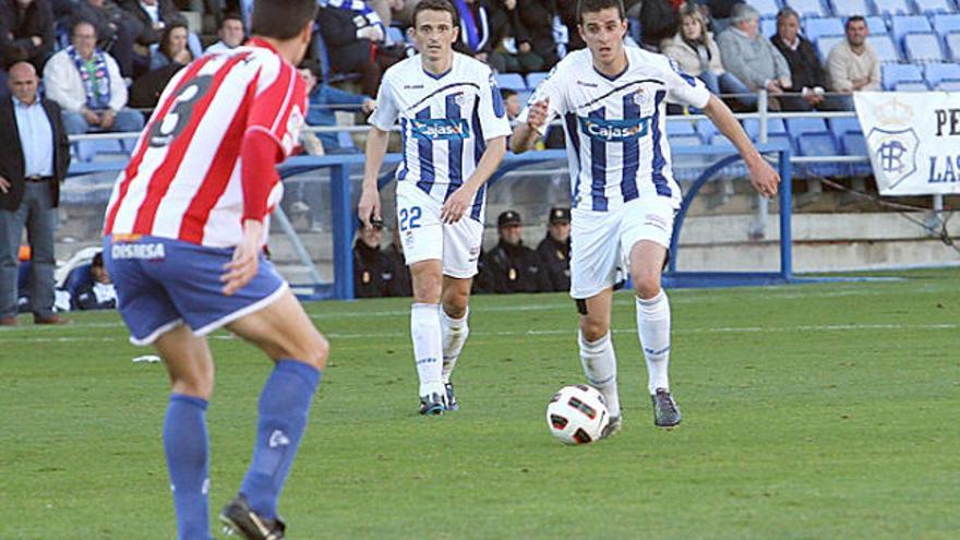 Albert Serra, a l&#039;esquerra, defensa l&#039;àrea del Girona davant d&#039;un atac del Recreativo. Jordi Matamala s&#039;ho mira atentament darrere del seu company |