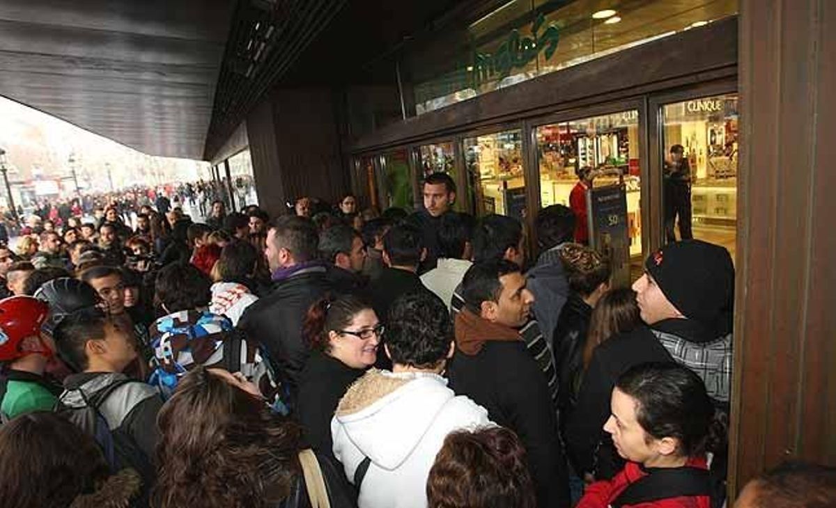 Moltes persones esperen l’obertura d’El Corte Inglés de plaça Catalunya, a Barcelona.