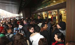 Moltes persones esperen l’obertura d’El Corte Inglés de plaça Catalunya, a Barcelona.