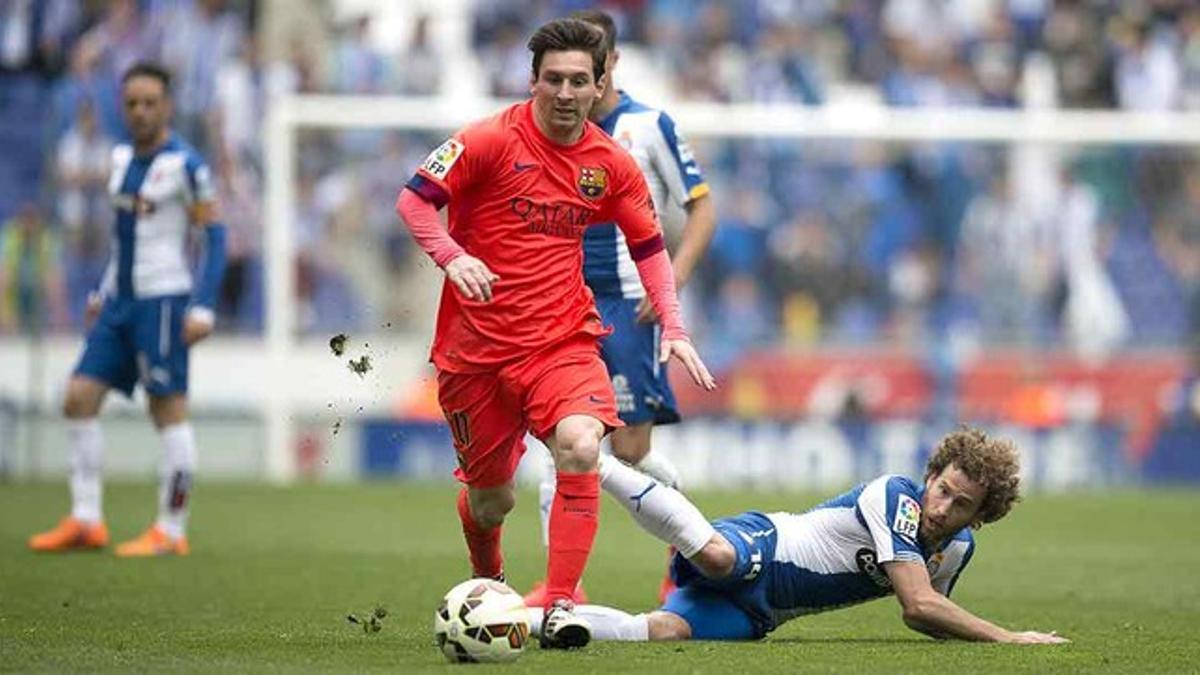 Messi supera una entrada de Cañas, durante el partido que ha enfrentado al Espanyol y el Barcelona en Cornellà