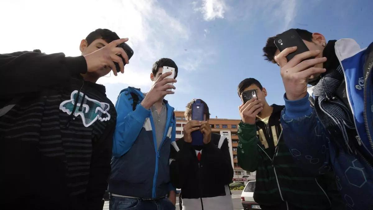 Varios jóvenes valencianos con sus teléfonos móviles en un IES, en una imagen de archivo.
