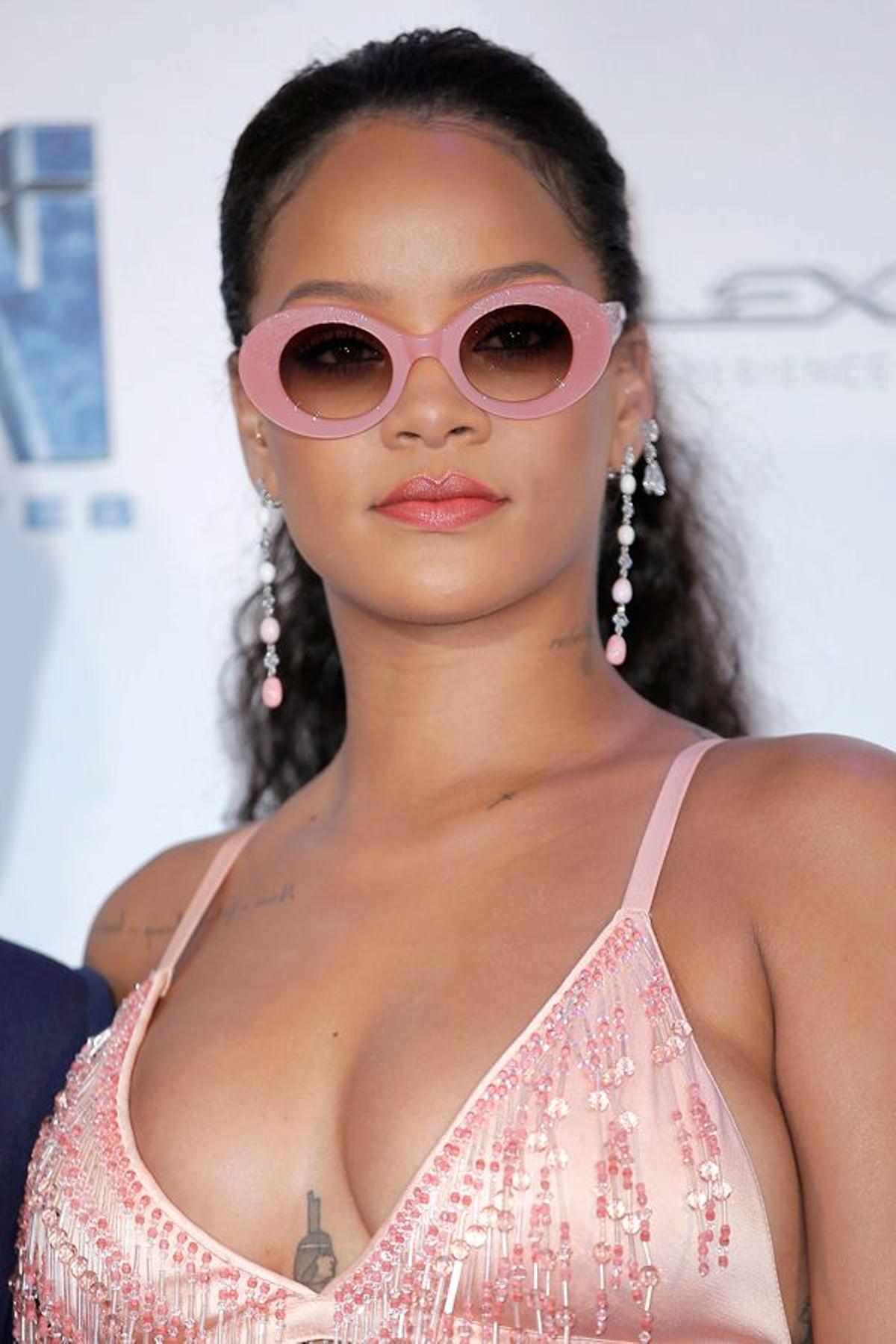 La cantante Rihanna posó con grandes gafas de sol rosas, a conjunto con su look