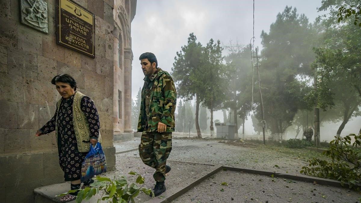 En Martuni (Azerbaiyán), un soldado acompaña a una mujer a un refugio