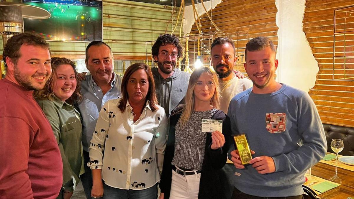 Miembros de la comisión de fiestas, en el acto de entrega del lingote de oro a la ganadora del sorteo, Lucrecia Pombo, segunda por la izquierda, sujetando la papeleta premiada. | R. M. V.