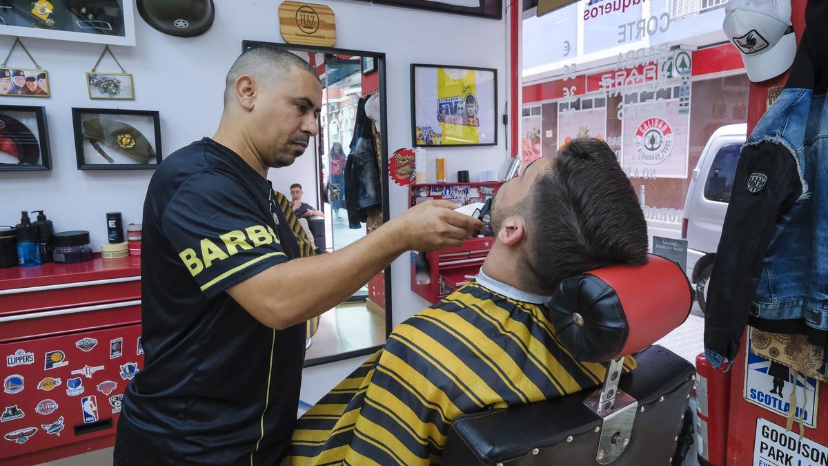 Un trabajador atiende a un cliente en una barbería.
