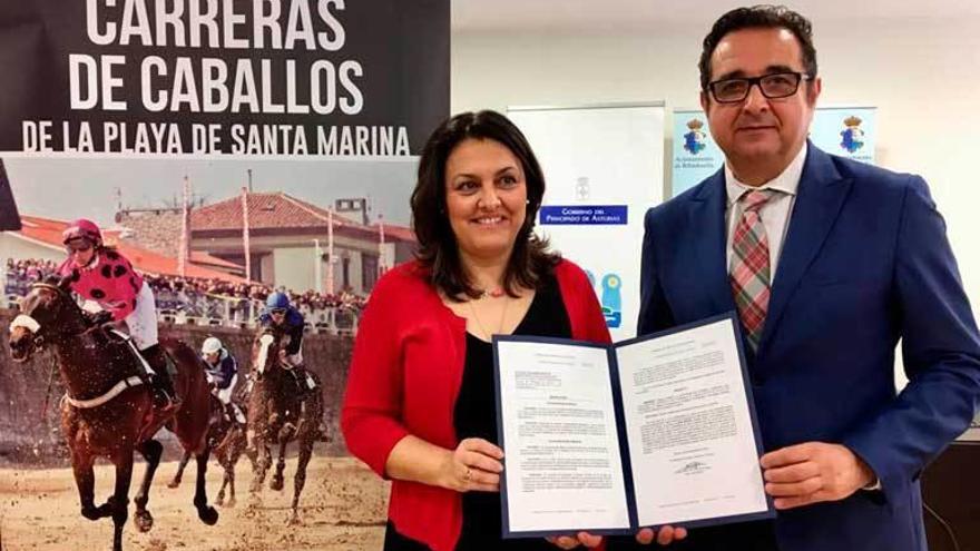 La alcaldesa de Ribadesella, Charo Fernández, y el director general de Comercio y Turismo, Julio G. Zapico, con la distinción que acredita las carreras de caballos como actividad de interés turístico, ayer.