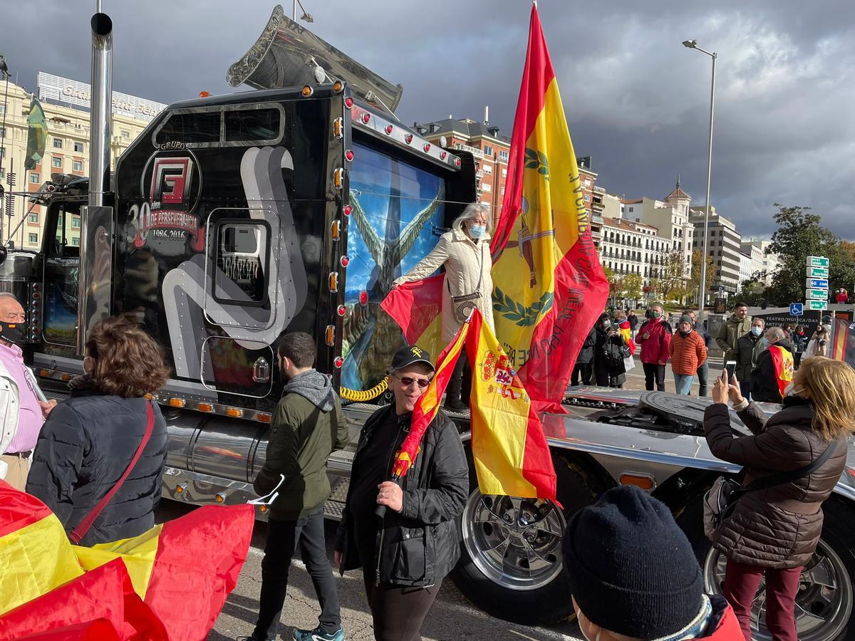 Una señora se fotografía con la gran bandera que llevaba el camión El Buitre Negro en la manifestación de Jusapol.