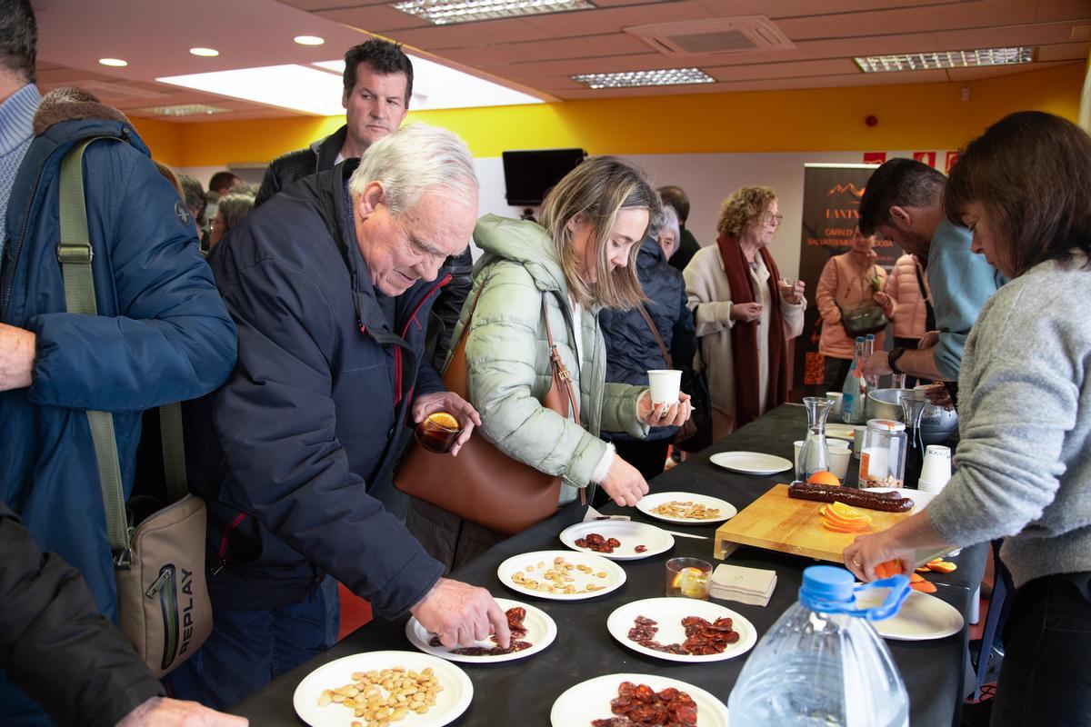 Veïns i veïnes degustant productes variats derivats de la caça.