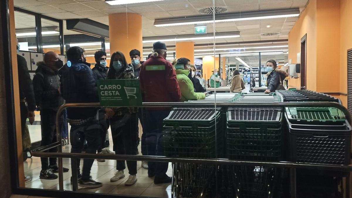 Viandantes refugiados en un supermercado ante el paso de los manifestantes y la policía.