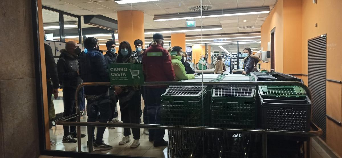 Viandantes refugiados en un supermercado ante el paso de los manifestantes y la policía.
