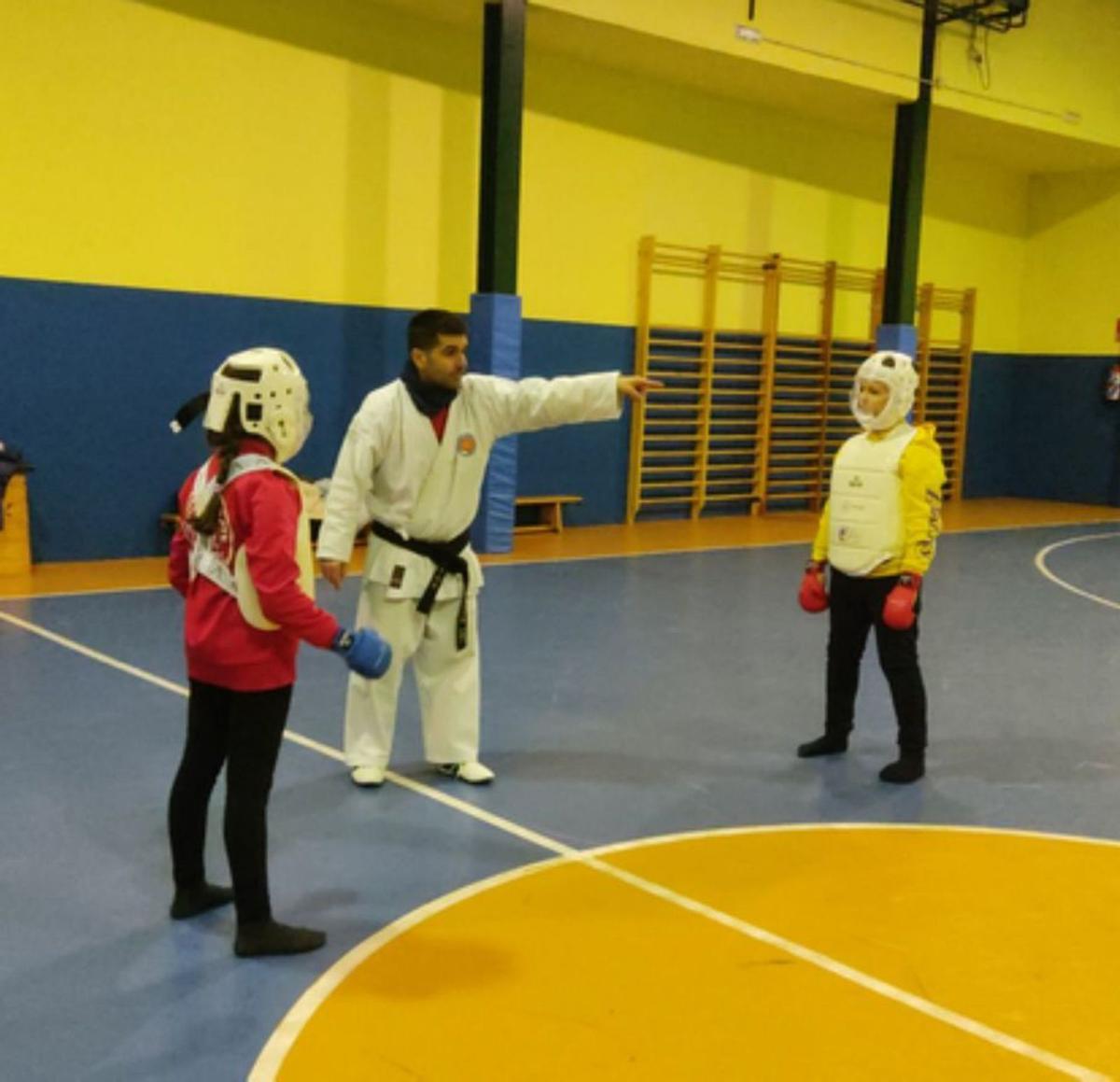 El presidente de Shotokan practica algunos ejercicios con una niña. | E. P.