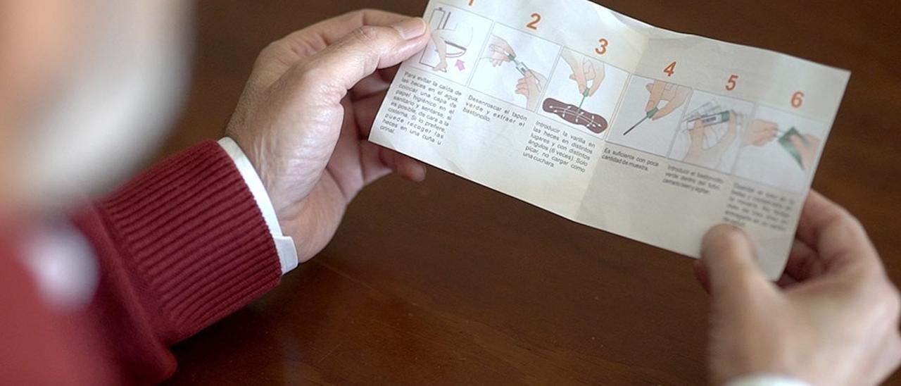 Un hombre lee un folleto con información sobre el cribado de colon.