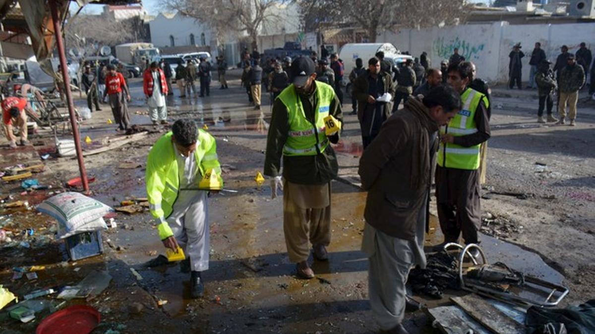 Crime scene investigators collect evidence from the site of a suicide bomb attack close to a polio eradication centre in Quetta