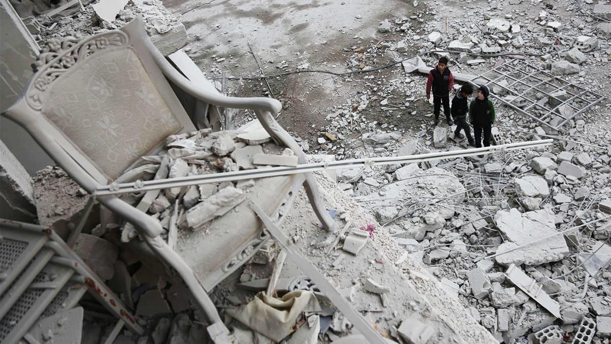 Niños frente a la destrucción en la ciudad de Arbin, en el este de Siria