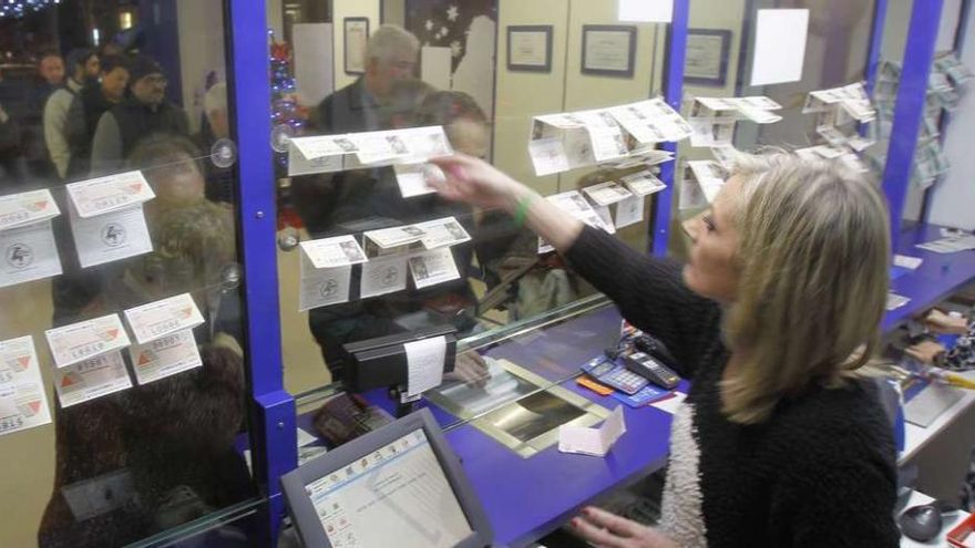Los clientes de la Administración de Lotería nº 10 hacen cola para comprar décimos. // José Lores