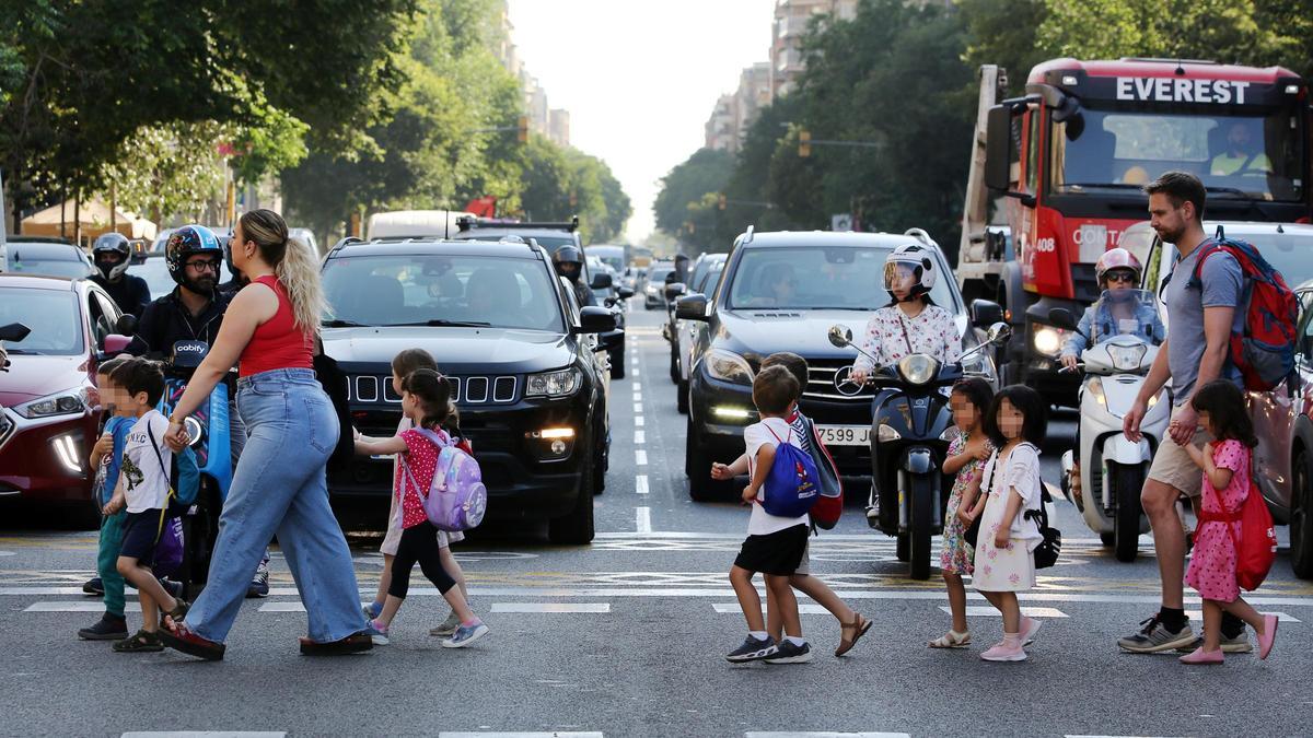 Un grupo de niños cruza la calle de Aragó de Barcelona ante la atenta mirada de los conductores