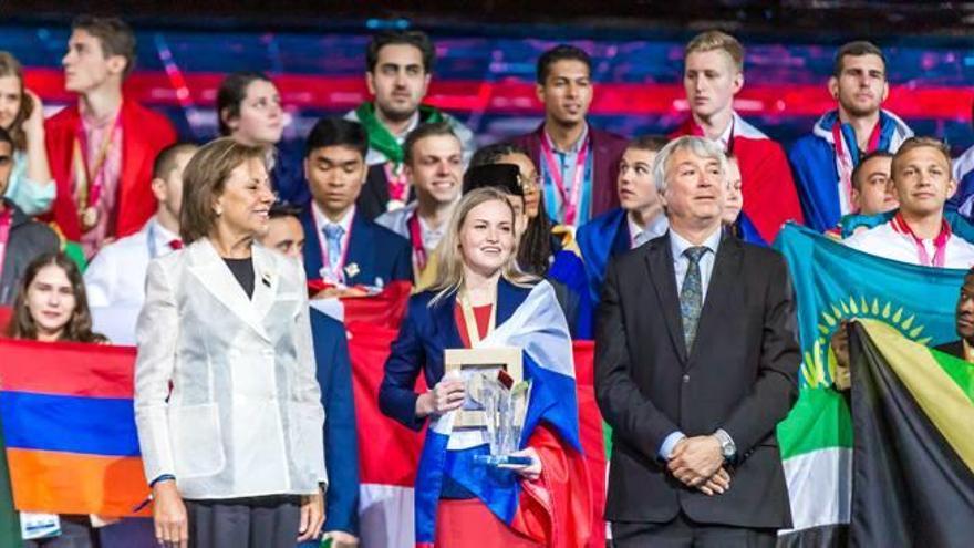 La filla de Francisco Albert Vidal entrega el guardó a la participant amb la puntuació més alta, junt amb el president de World Skills, SImon Bartley.