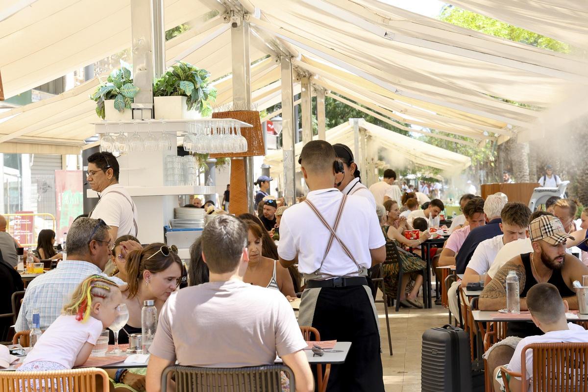 Camareros atendiendo la terraza de un restaurante en Alicante.