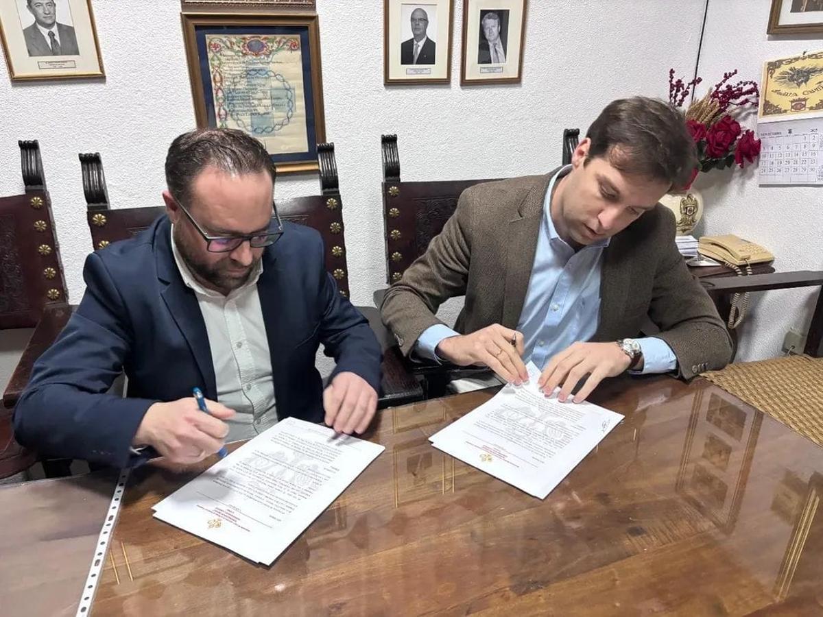 El hermano mayor de la Caridad y el director de la banda de Coronación firman el contrato.