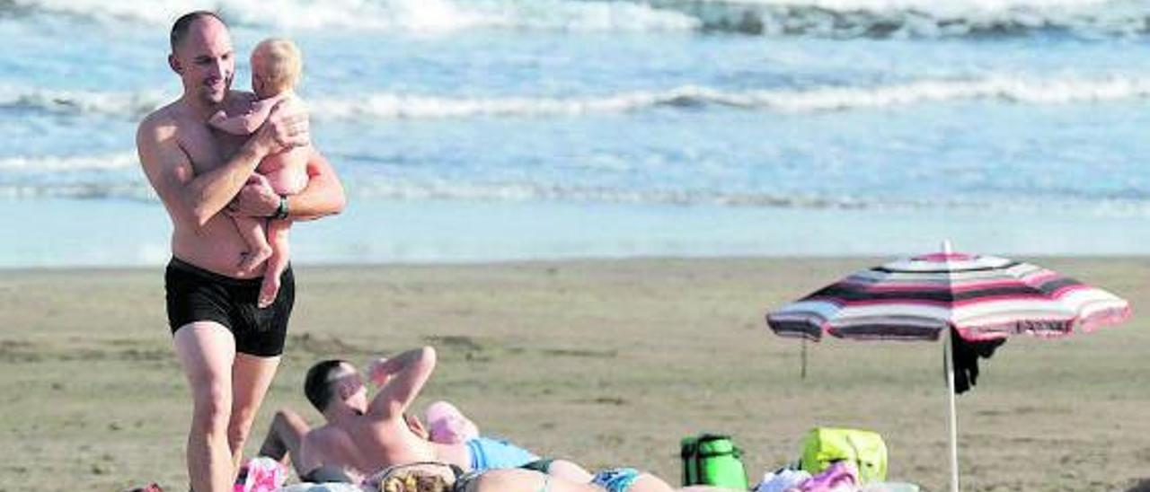 Grupos de turistas disfrutan de una playa del sur de Gran Canaria .