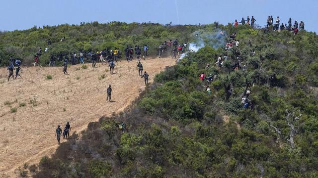 Desenes de migrants que esperaven travessar cap a Espanya, ahir, en una zona muntanyosa de Castillejos (Marroc), a prop de la frontera de Ceuta.  | ALAL MORCHIDI / EFE