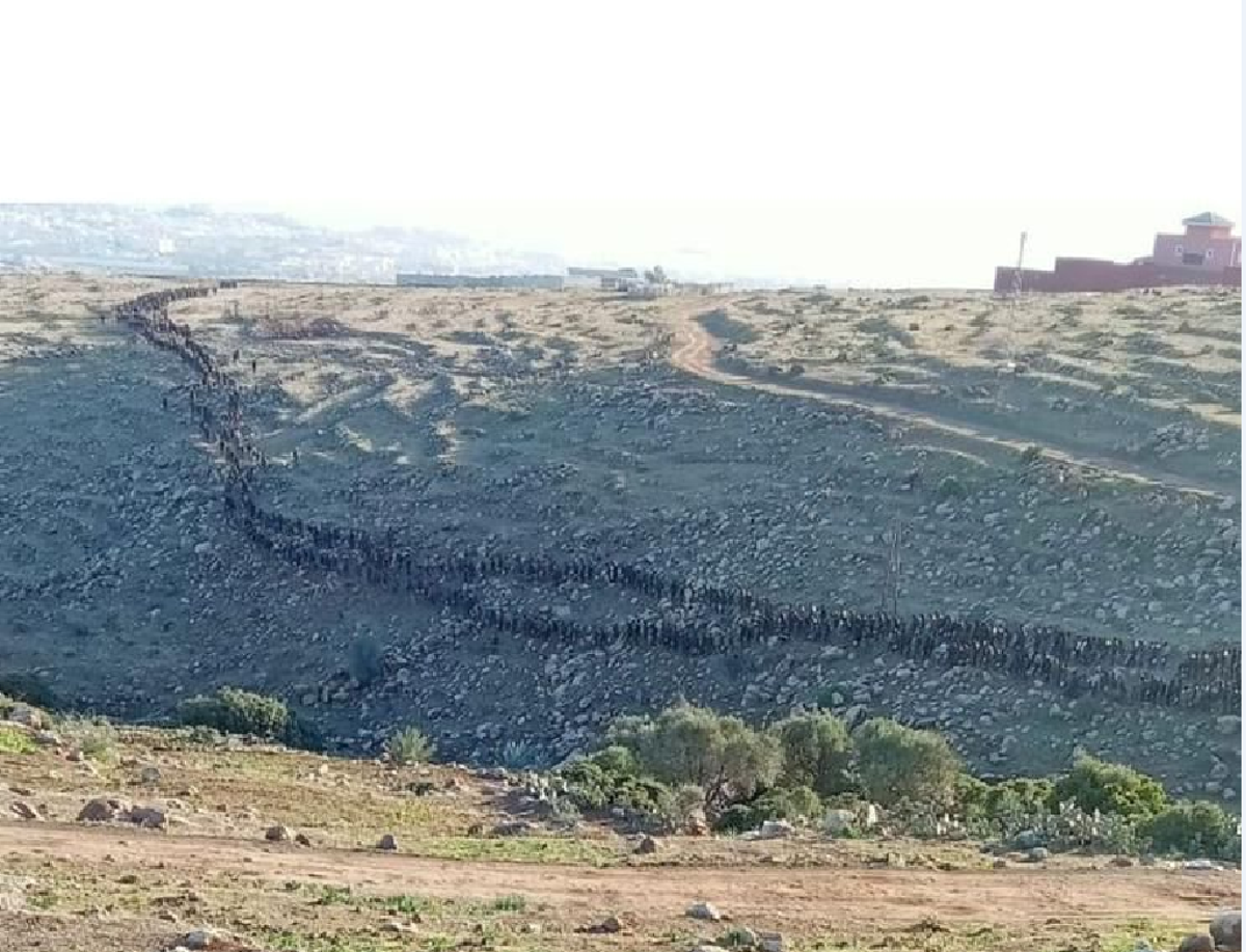 Una hilera de inmigrantes se dirige a Melilla desde el monte Gurugú poco antes del intento de salto de la valla que separa a Marruecos de territorio español.