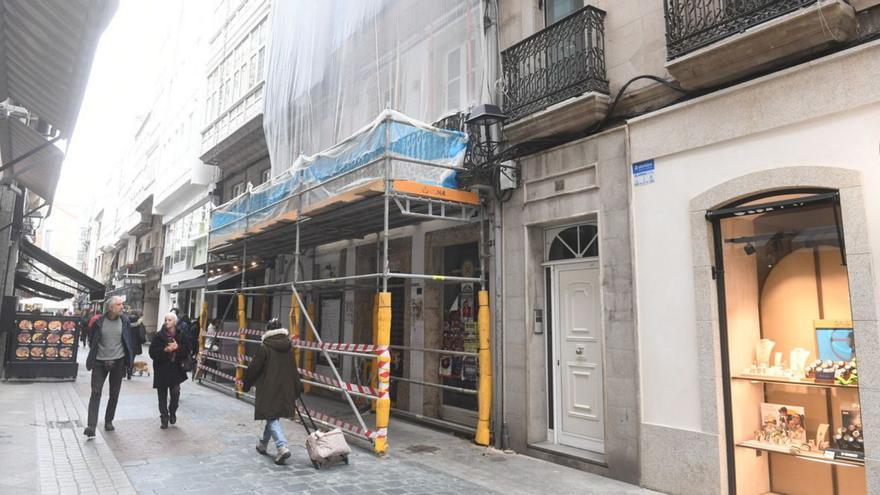 Edificio número 25  de la calle Olmos, con un andamio  y y una red cubriendo la fachada.   | // CARLOS PARDELLAS