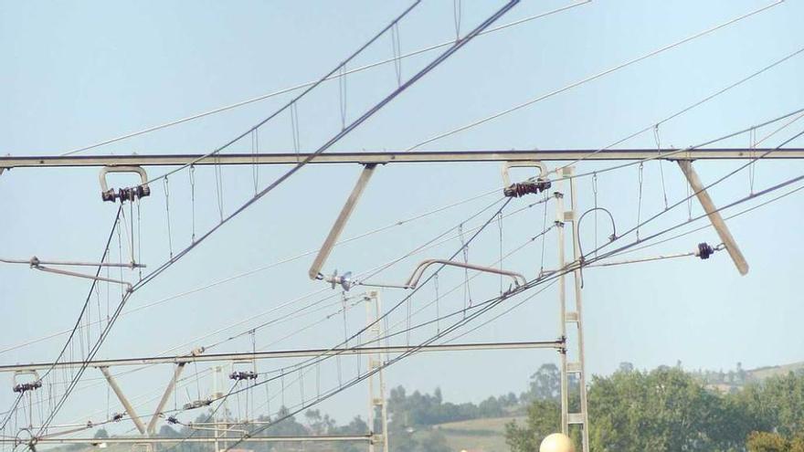 Un usuario cruza las vías en la estación de tren de Noreña.