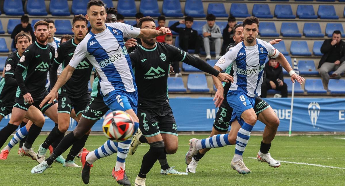 Primi Férriz y Juanan Casanova disputan un balón en el área de El Collao frente al Atlético Baleares