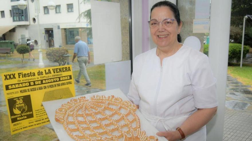 María Eugenia Fernández Doval, ayer, con la venera en el escaparate de su pastelería. | Reproducción de D. Á.