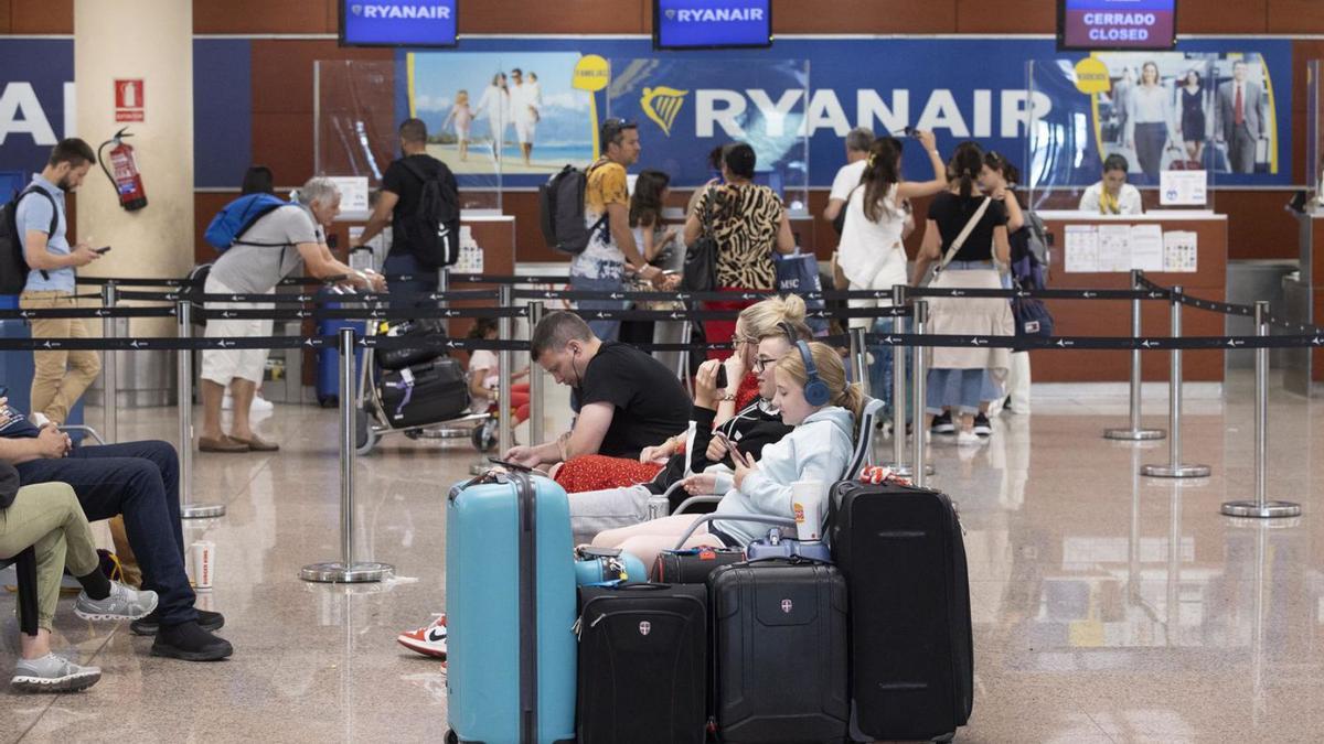 Passatgers al costat dels mostradors de la companyia Ryanair a l’aeroport del Prat. | FERRAN NADEU