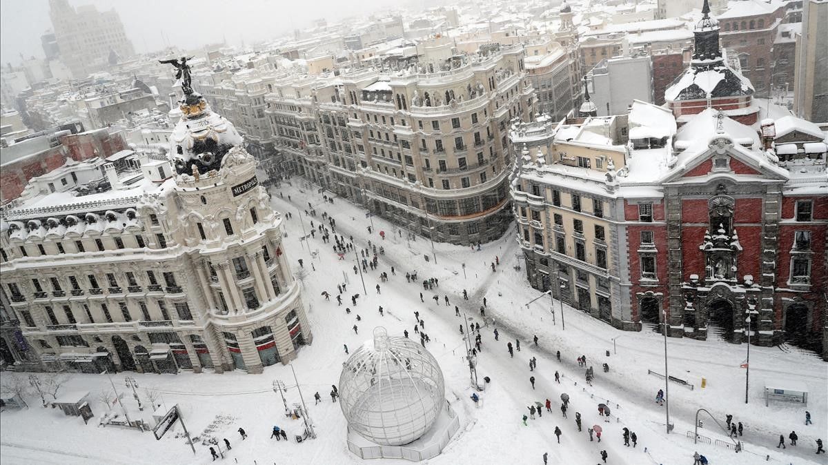 People are seen from the rooftop of the Circulo de Bellas Artes cultural center  as they walk at the start of Gran Via street during a heavy snowfall in Madrid  Spain January 9  2021  REUTERS Susana Vera