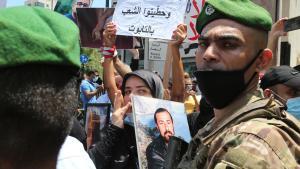 Una mujer sostiene un retrato de un familiar fallecido frente a los soldados que bloquean el acceso al Palacio Ain al-Tineh, la residencia del presidente del Parlamento, en Beirut, Líbano.