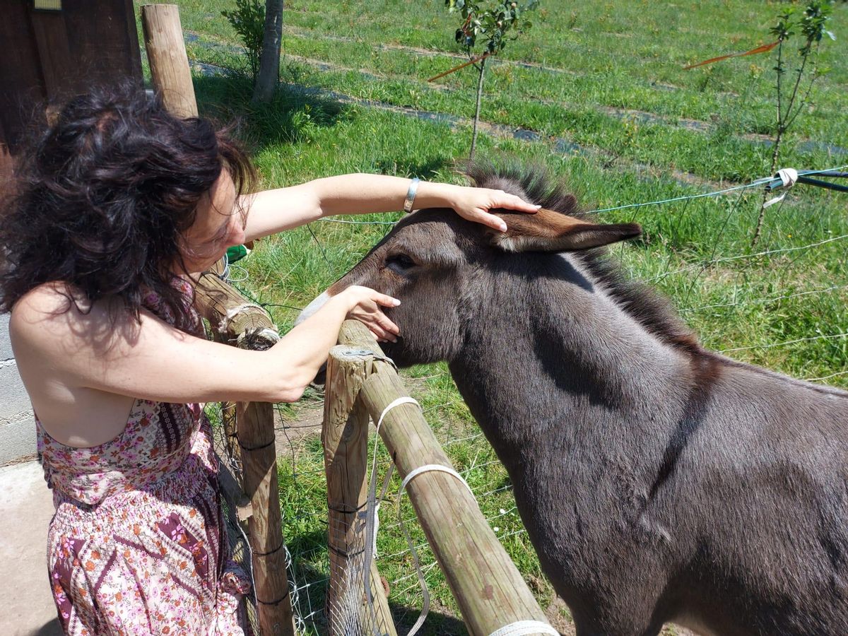 Thaïs acaricia a su burro.
