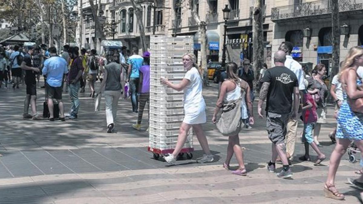 LA RAMBLA DEL 2014  Una trabajadora cruza la Rambla entre turistas, ayer.