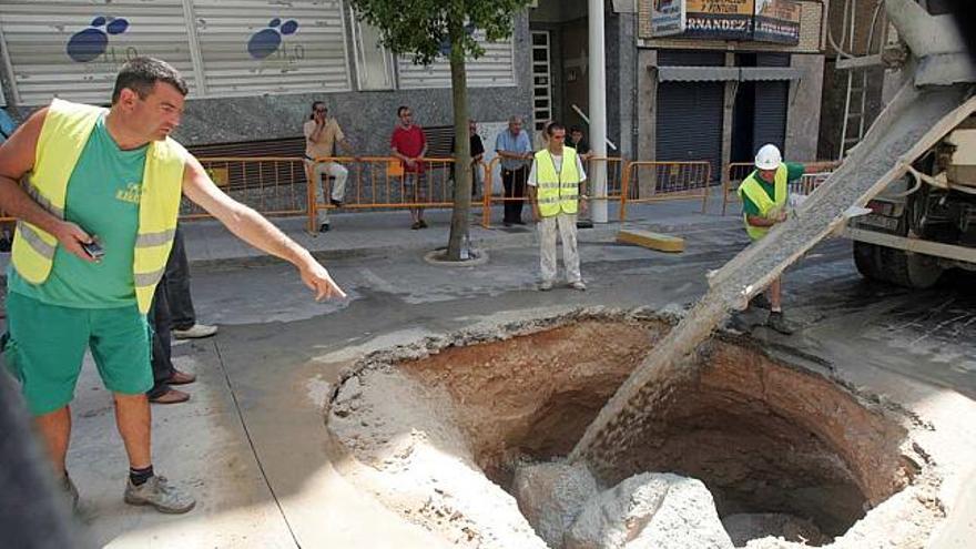 El socavón, que despertó gran expectación en el barrio, fue rellenado ayer con cemento y escollera.