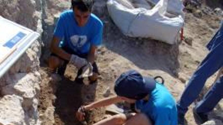 El campo de trabajo de Banys de la Reina llega este verano a su XV edición.Voluntarios y arqueólogos excavan el enterramiento del siglo VI.Los vestigios marinos del yacimiento forman una piscina «natural».La directora de la excavación, Alicia Luján, sostiene una de las muchas teselas que salen a la luz.