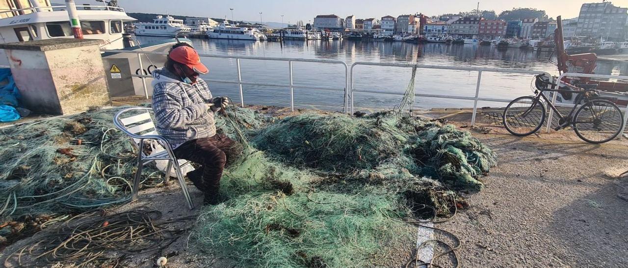 Un hombre se encarga de retirar la red de los &quot;miños&quot; hasta ahora dedicados a la pesca de centollo.