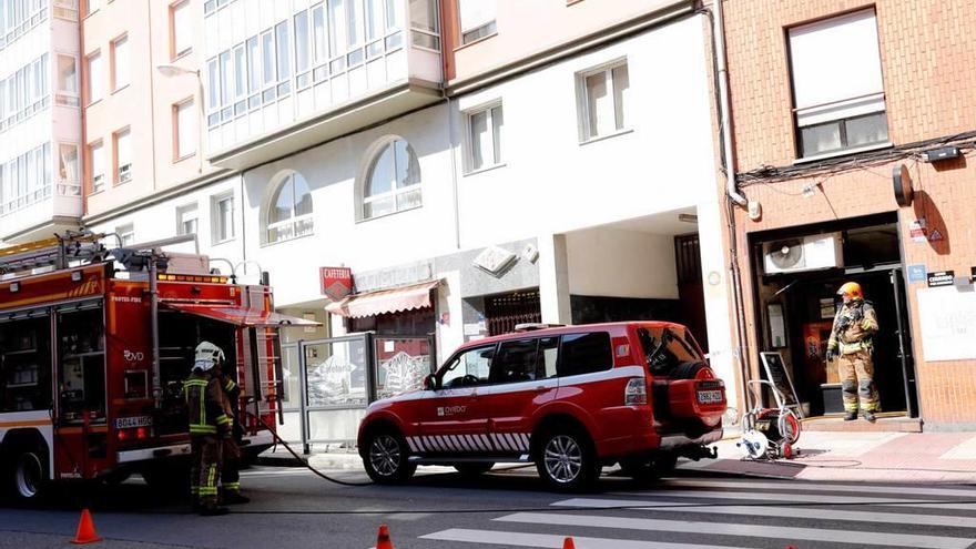 Los bomberos salen de la sidrería tras extinguir las llamas.