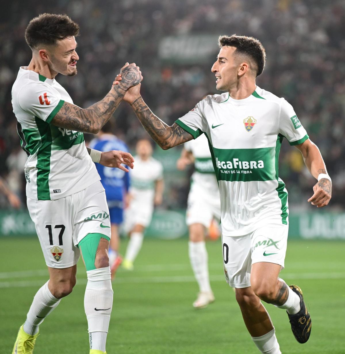 Josan and Fernández Mercau collide their hands after scoring a goal.