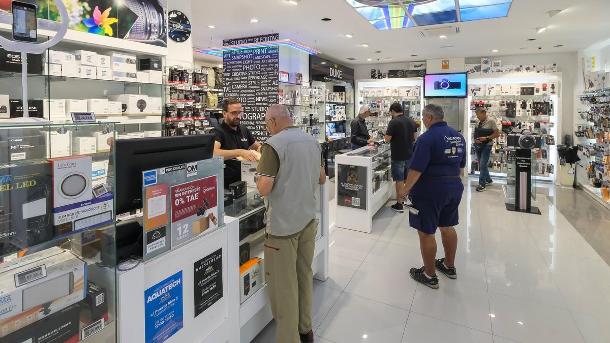 Un empleado atiende a un cliente en una empresa de fotografía.