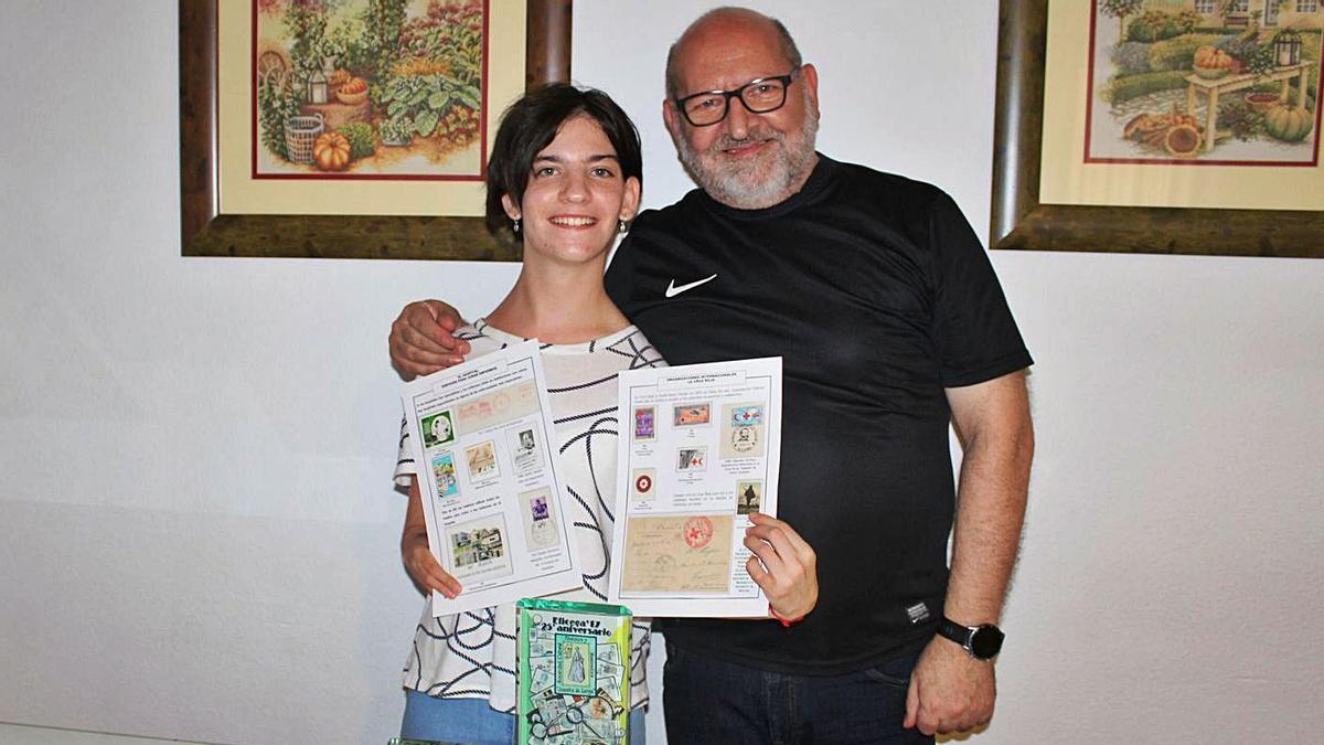 Mercedes, junto a su padre Juan, enseñando algunas páginas de su colección.