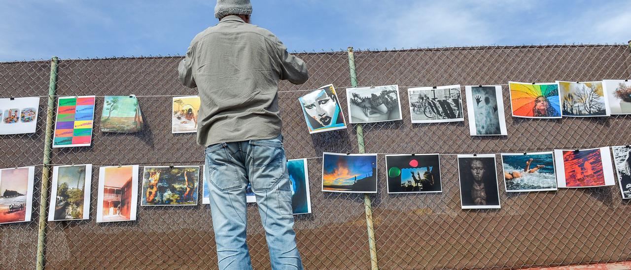 Un transeúnte fotografía varias pinturas en la avenida de Ingenio, este viernes.